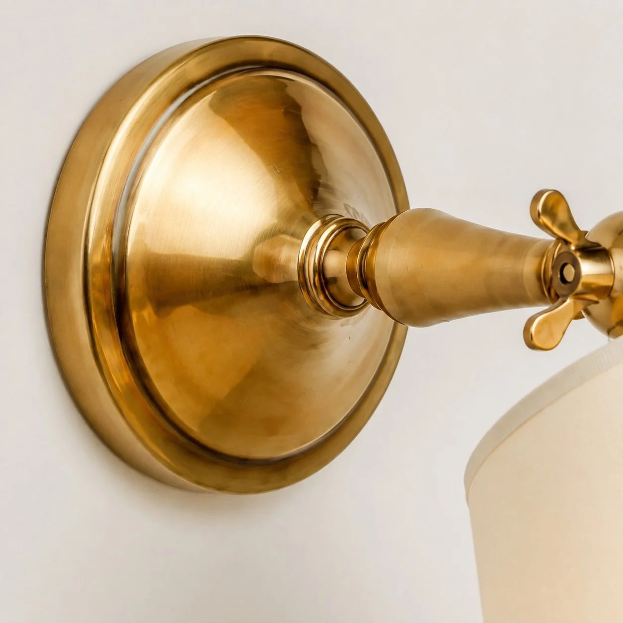 Round wall plate and brass arm detail