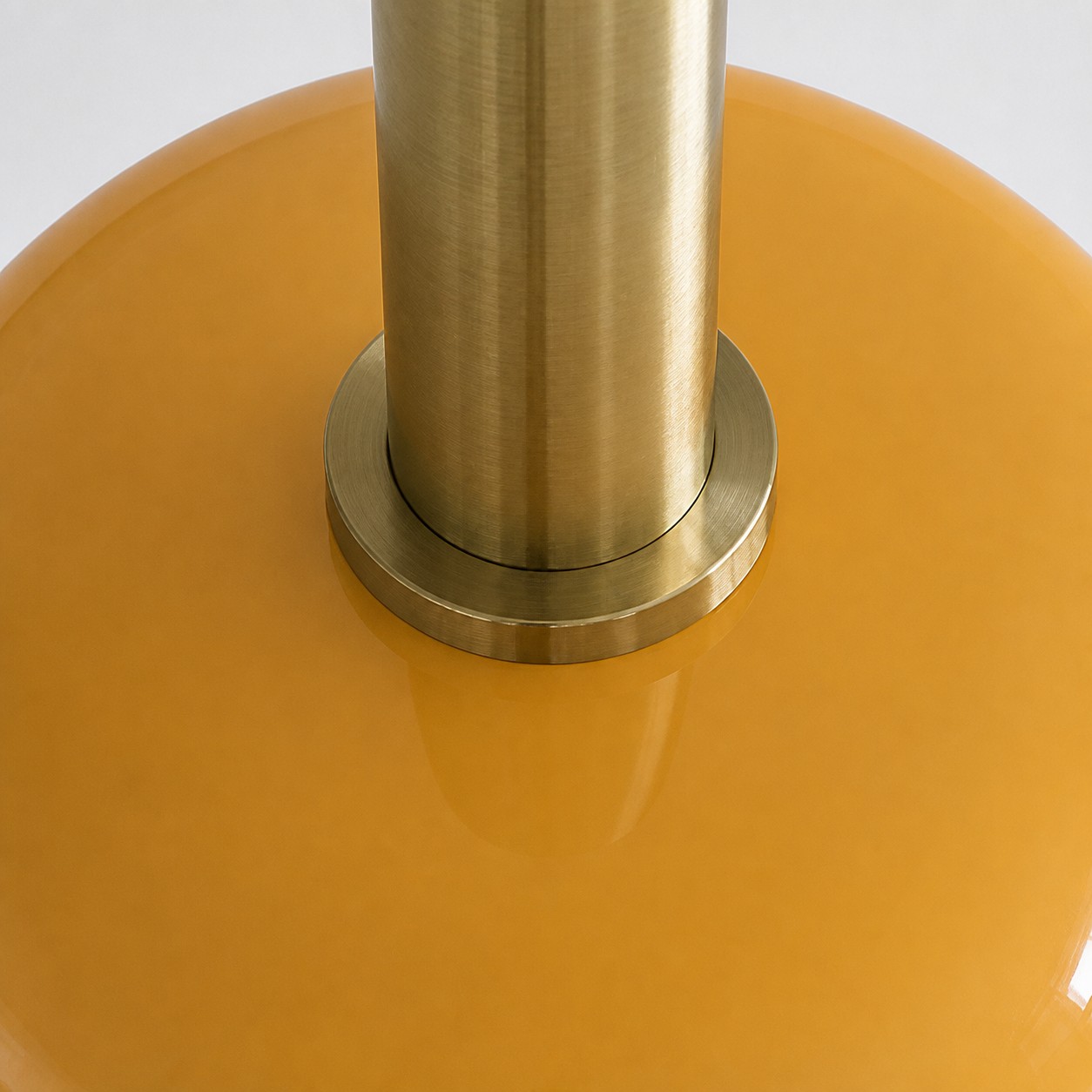 Close view of the brass holder and yellow glass shade connection