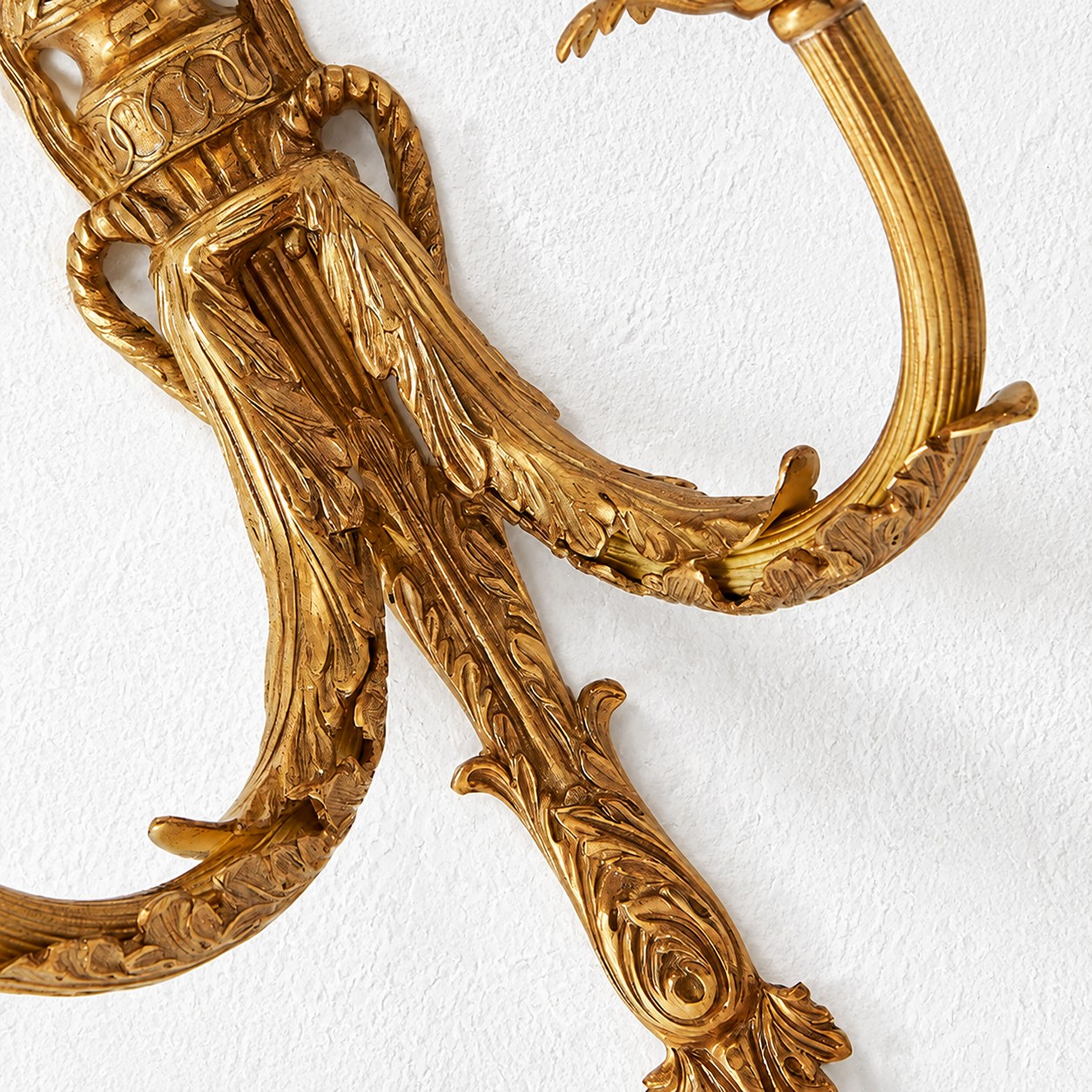 Close view of the curved carved brass arm detail