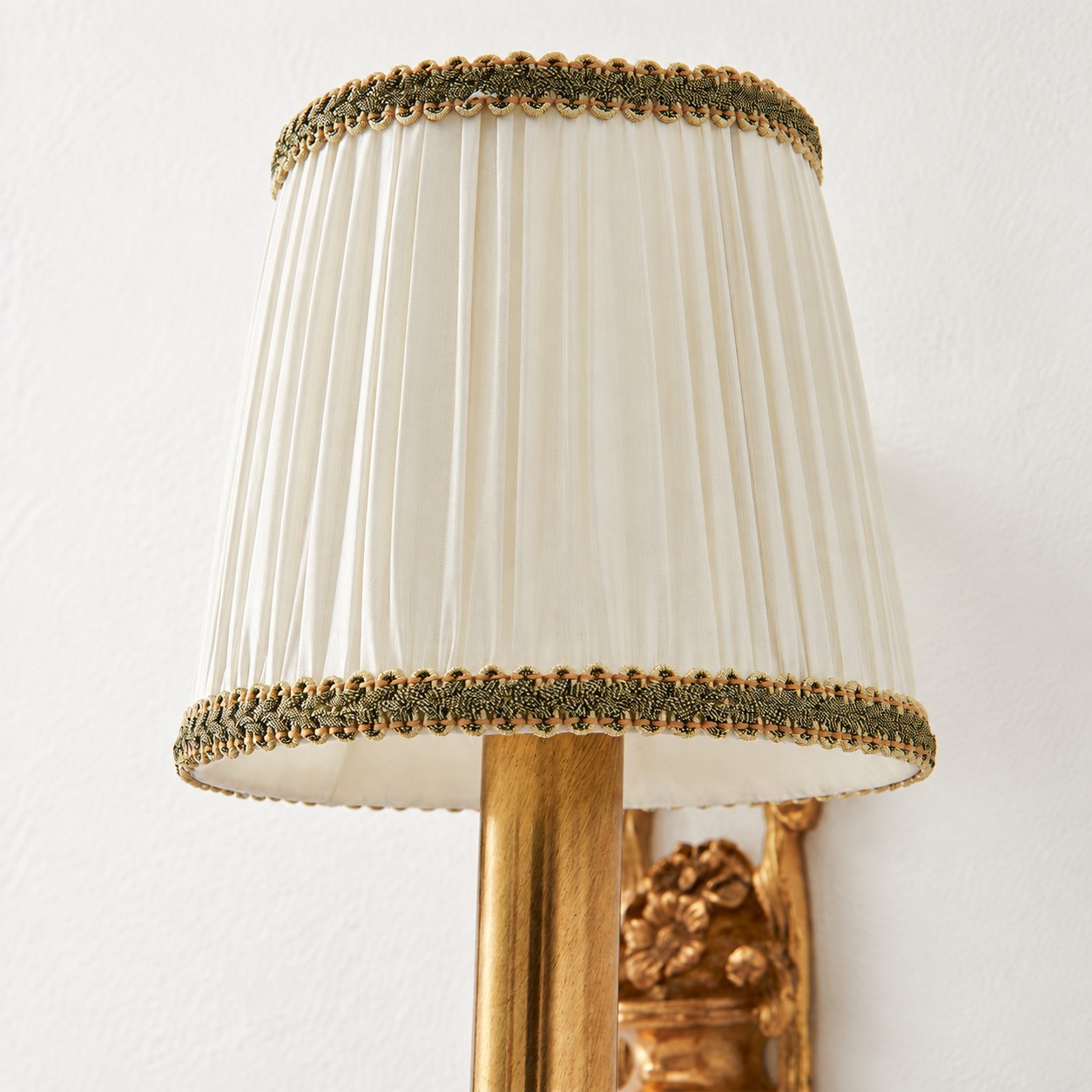 Close view of the white pleated fabric lampshade with brass trim