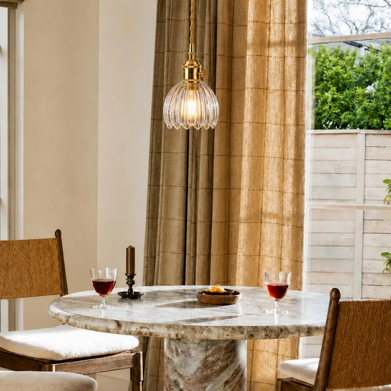 Amber ribbed tulip glass pendant glowing above a dining setting