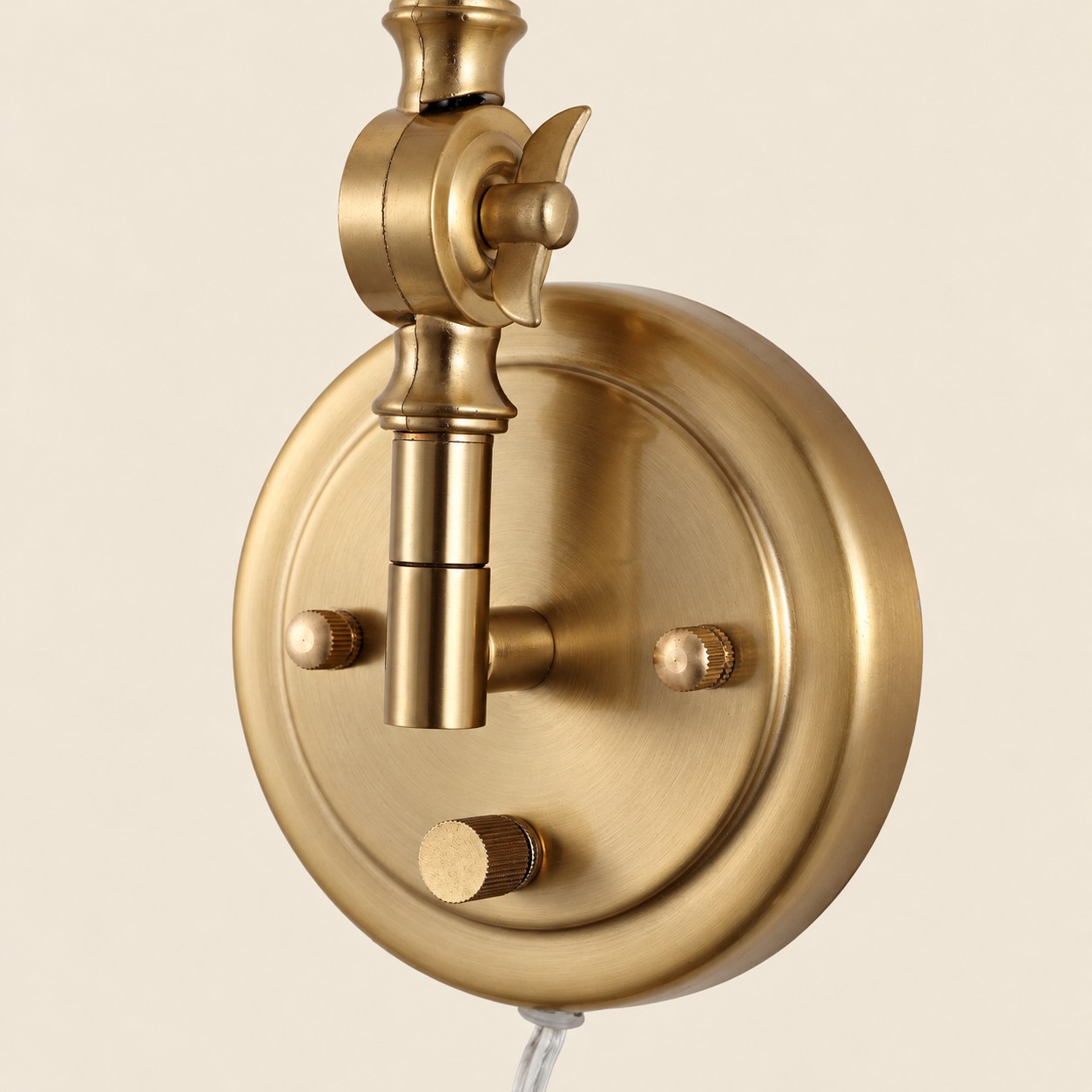 Close view of the round gold backplate and cord exit