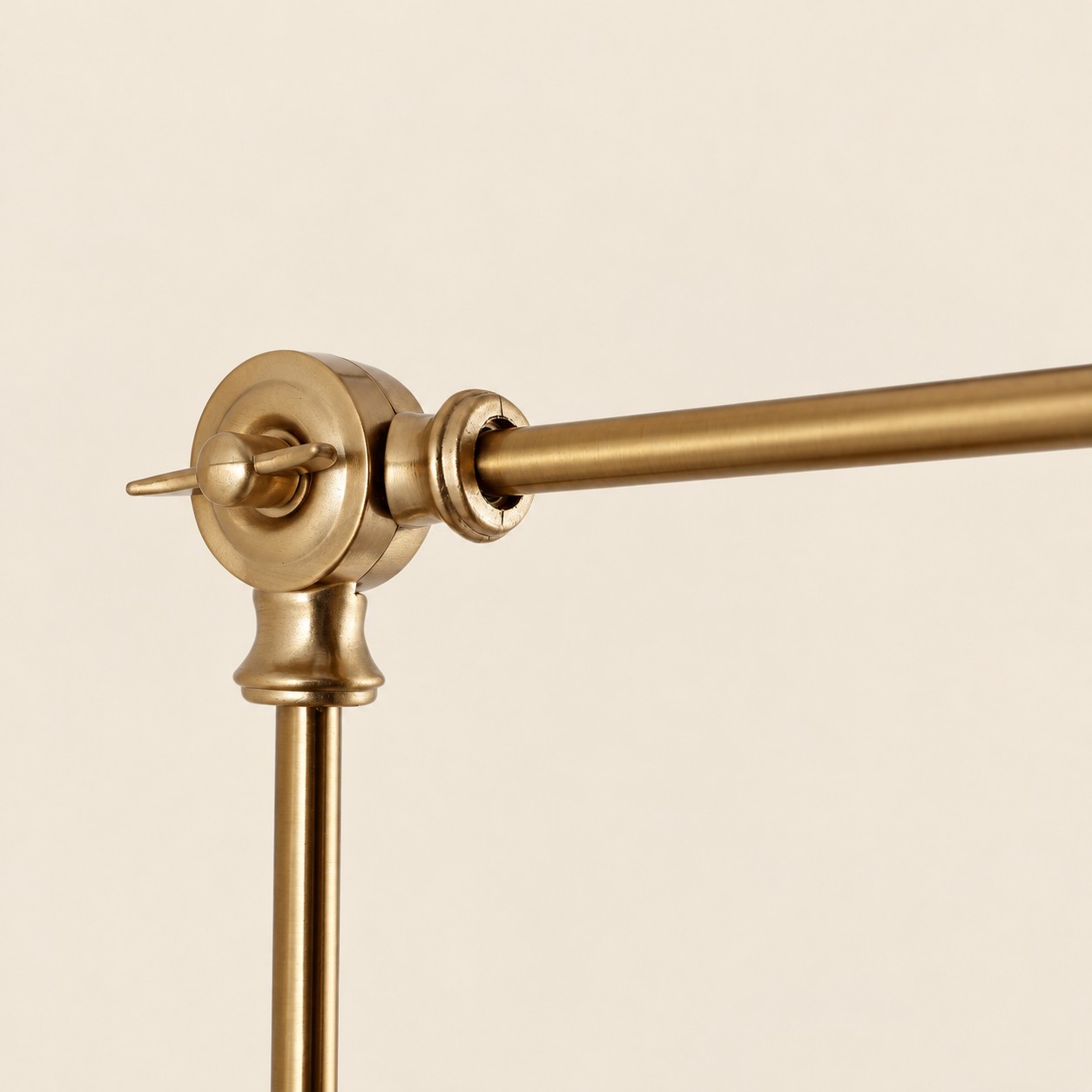 Close view of the gold swing-arm joint and adjustment knob