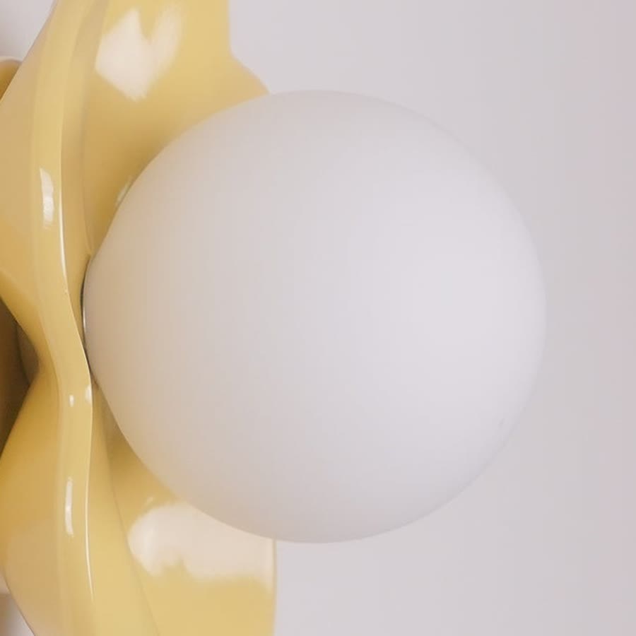 Difusor de cristal redondeado: La esfera blanca y lisa difunde la luz en el centro de la flor.